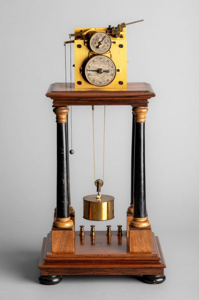 A Hipp chronoscope with a large cylindrical weight falling between four turned wooden pillars